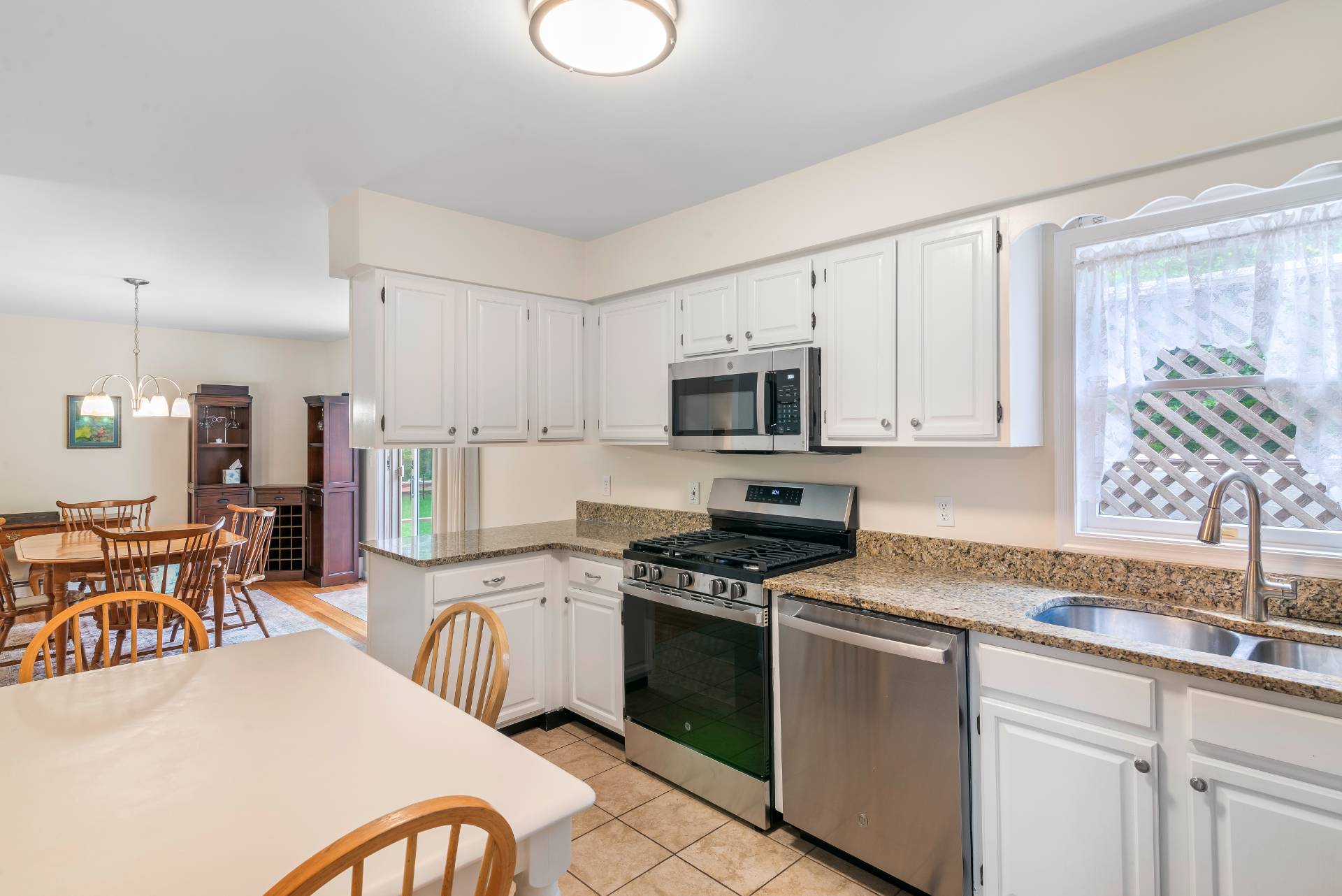 75 Edwards Avenue East Hampton, NY 11937 - Photo 8 of 27 a kitchen with stainless steel appliances granite countertop a stove top oven a sink dishwasher a dining table and chairs with wooden floors