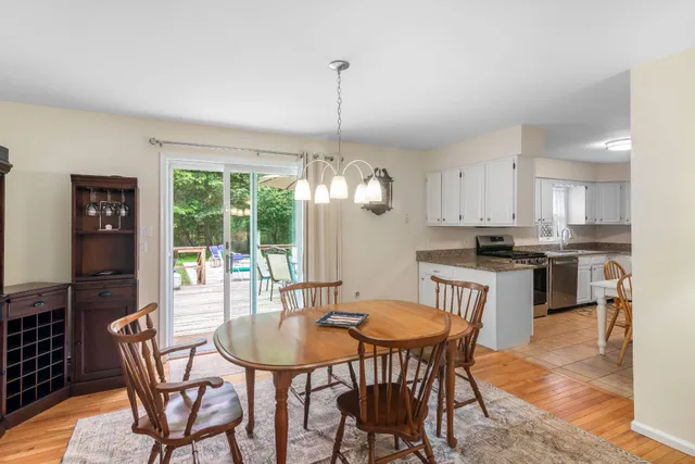 a dining room with furniture a chandelier and kitchen view