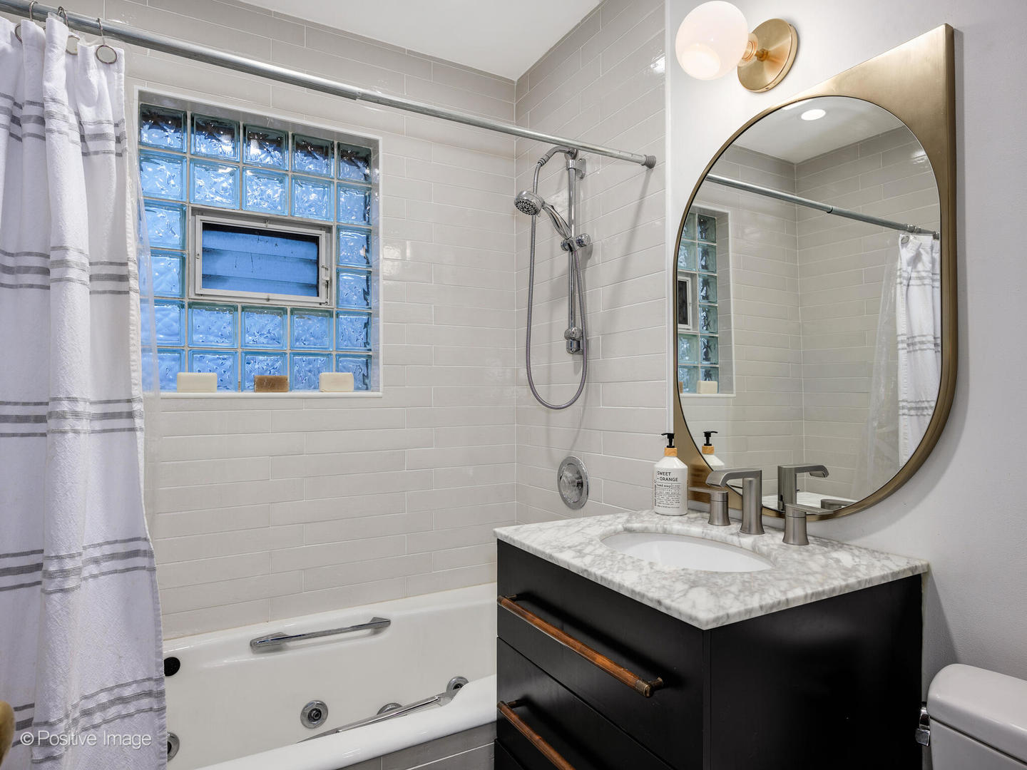 225 Clinton Avenue Oak Park, IL 60302 - Photo 18 of 37 a bathroom with a sink a vanity a mirror and a bathtub