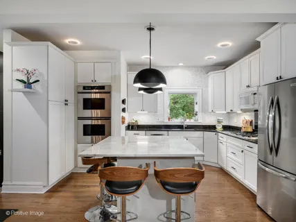 a kitchen with stainless steel appliances granite countertop a stove refrigerator and cabinets