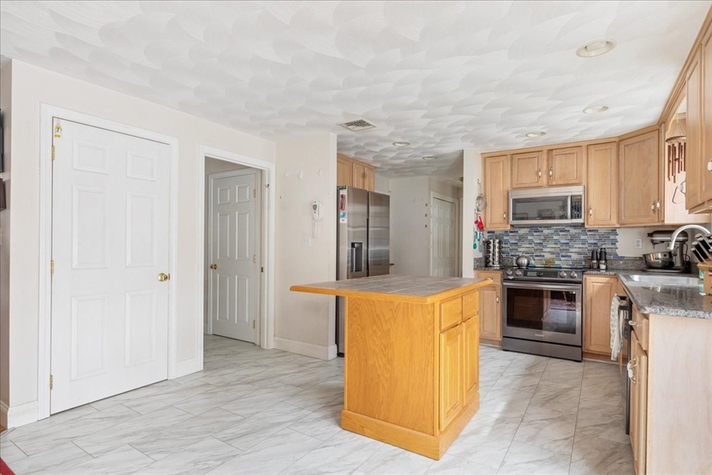 5 Lynn Street Taunton, MA 02780 - Photo 8 of 26 a kitchen with stainless steel appliances a stove top oven a sink and a refrigerator