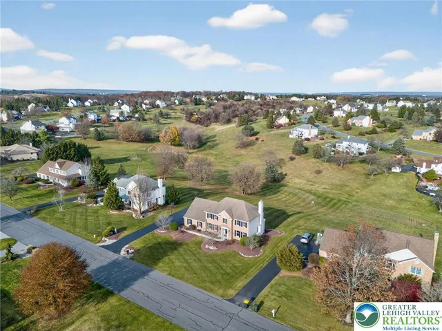 a front view of a house with garden and trees