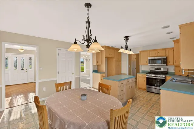 a open kitchen with stainless steel appliances kitchen island granite countertop a stove top oven a sink a counter top space and cabinets