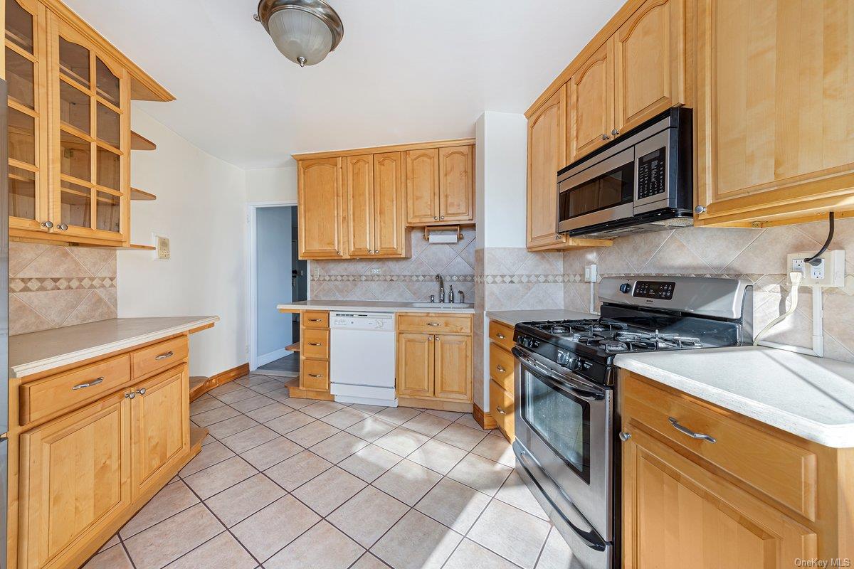 3121 Middletown Road, Unit 2K Bronx, NY 10461 - Photo 7 of 18 a kitchen with stainless steel appliances granite countertop a stove a sink and a microwave