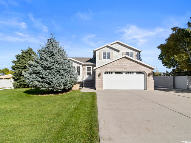 7063 Orion Hill Road West Jordan, UT 84081 - Photo 1 of 1 View of front of home with a front lawn and a garage