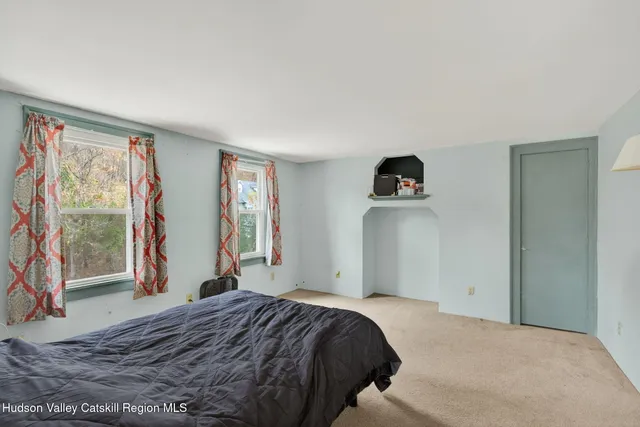 a bedroom with a bed and a large window