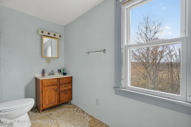 a bathroom with a toilet a sink and a window