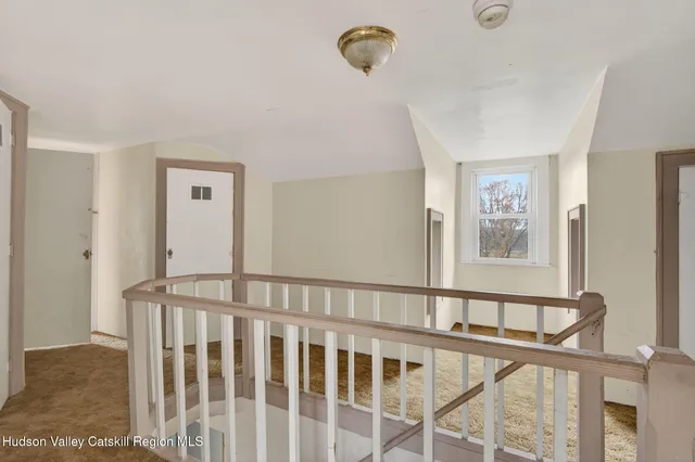 a view of staircase with railing and a rug