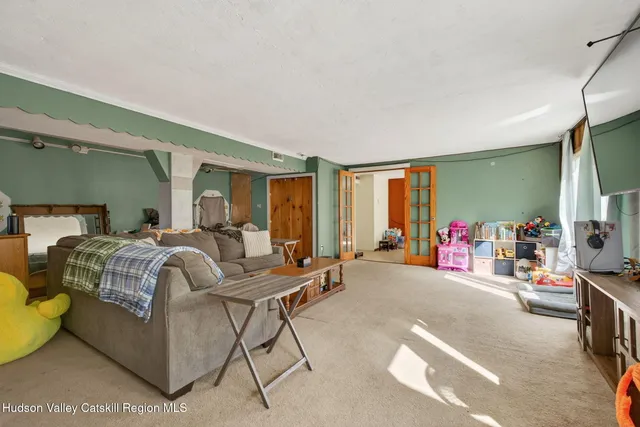 a living room with furniture a flat screen tv and a window