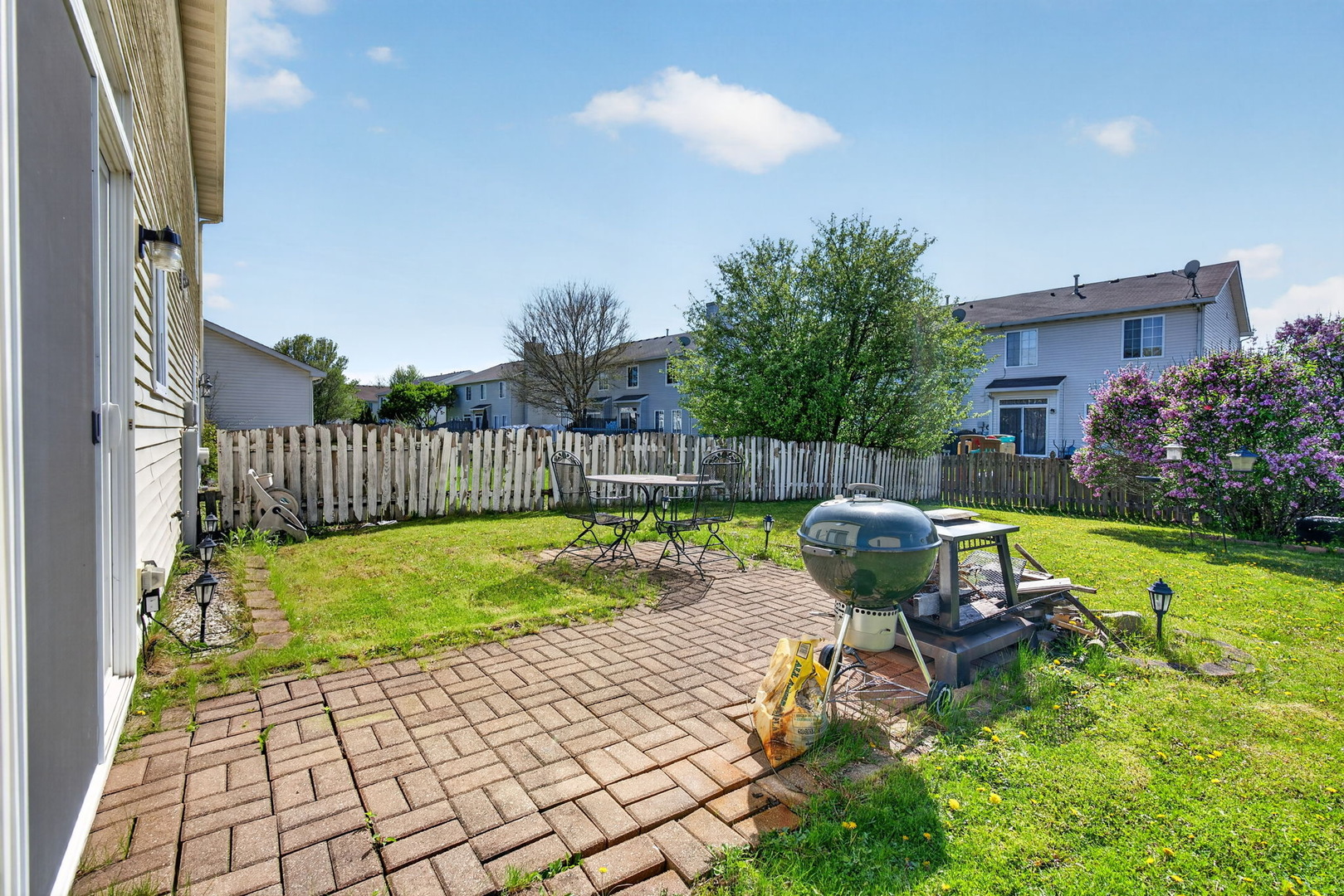 1429 Levato Lane Minooka, IL 60447 - Photo 24 of 27 a view of a backyard with table and chairs with wooden fence and plants
