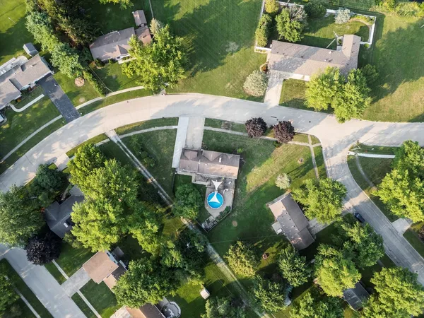 an aerial view of a house with a yard and green space