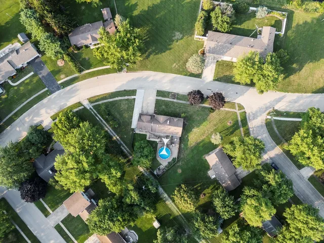 an aerial view of a house with a yard and green space
