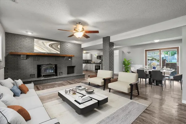 a living room with furniture a fireplace and a large window