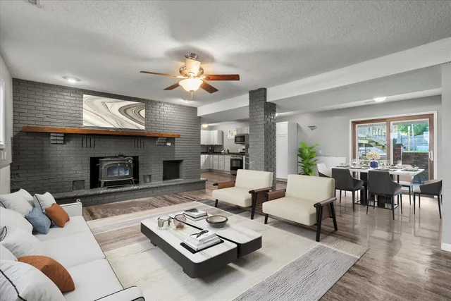 a living room with furniture a fireplace and a large window