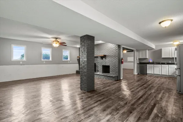 a view of a big room with wooden floor and windows