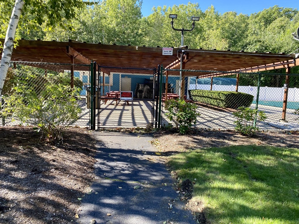 5 Beal's Cove Road, Unit B Hingham, MA 02043 - Photo 27 of 27 a view of patio with table and chairs under an umbrella with a small yard