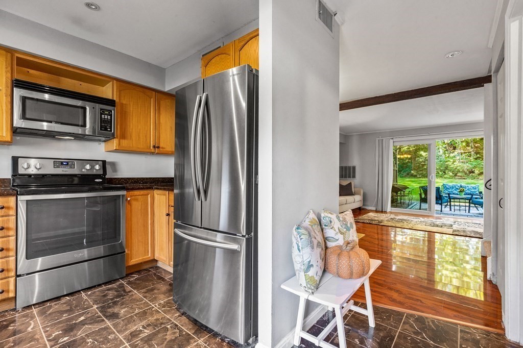 5 Beal's Cove Road, Unit B Hingham, MA 02043 - Photo 6 of 27 a kitchen with stainless steel appliances wooden floor and a refrigerator