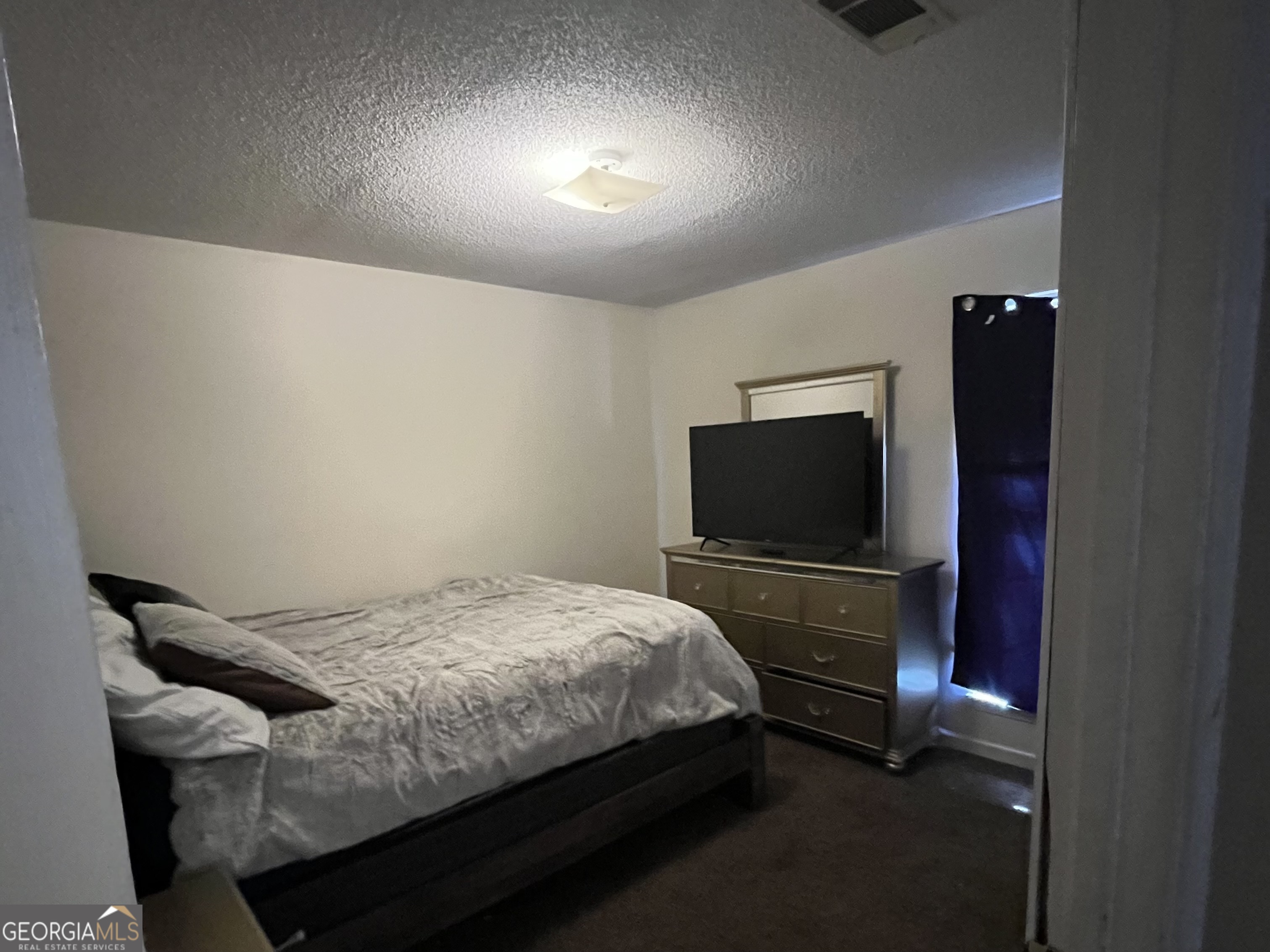 621 Pinewood Street Folkston, GA 31537 - Photo 12 of 14 a bedroom with a bed and a flat screen tv