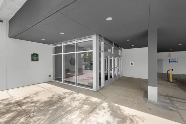a view of an empty room with wooden floor and windows
