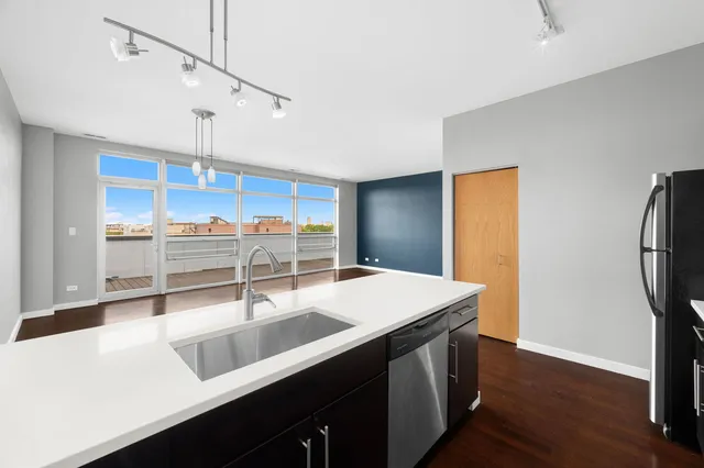 a kitchen with stainless steel appliances a sink a counter space and wooden floor