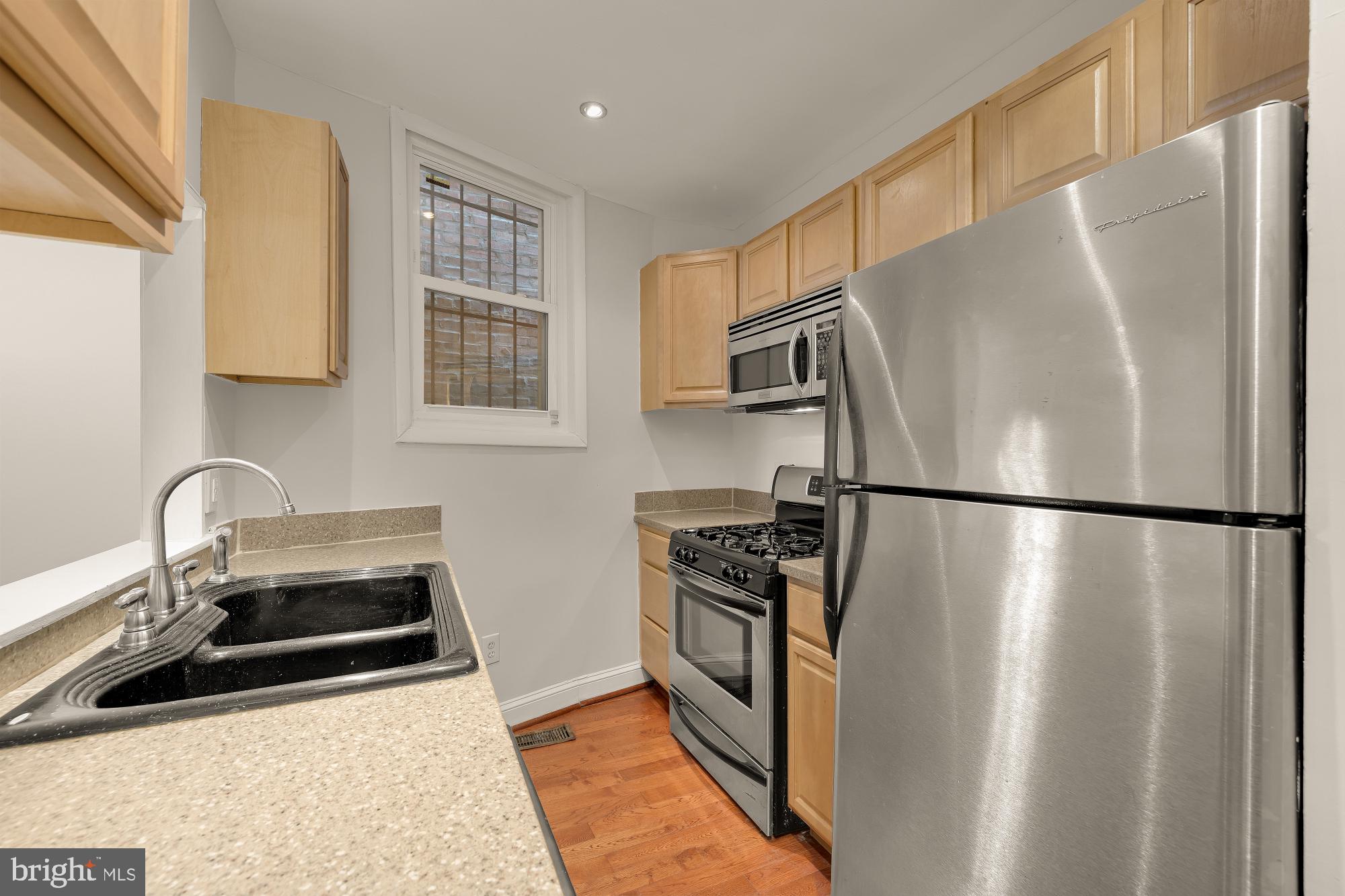 601 L Street Northeast Washington, DC 20002 - Photo 12 of 47 a kitchen with stainless steel appliances a refrigerator a sink a stove and white cabinets