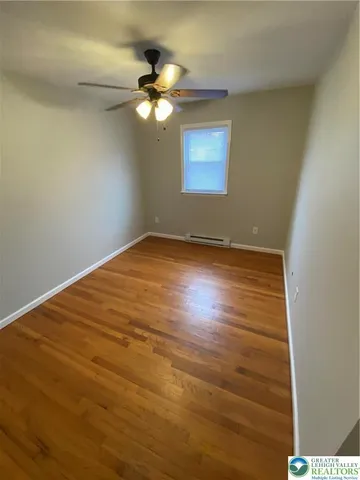 a view of an empty room with a chandelier fan