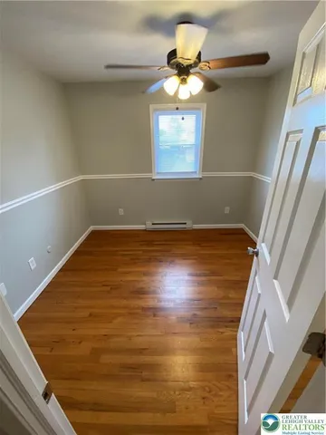 a view of a room with wooden floor and chandelier