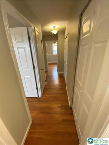 a view of a hallway with wooden floor and staircase