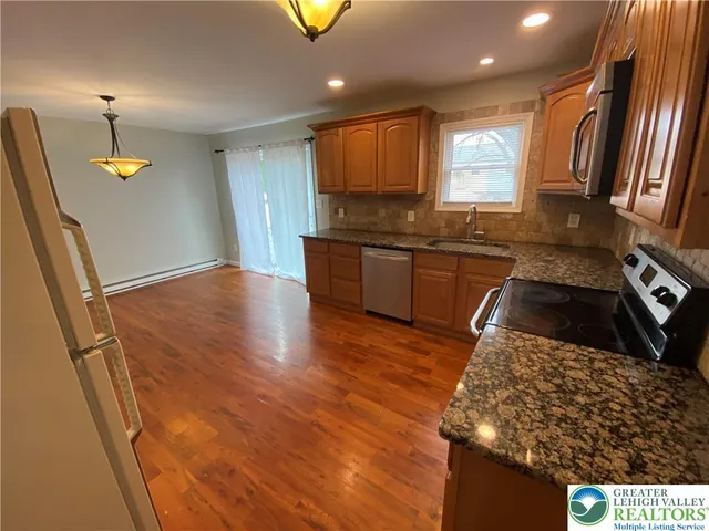 a kitchen with stainless steel appliances granite countertop a sink stove and refrigerator