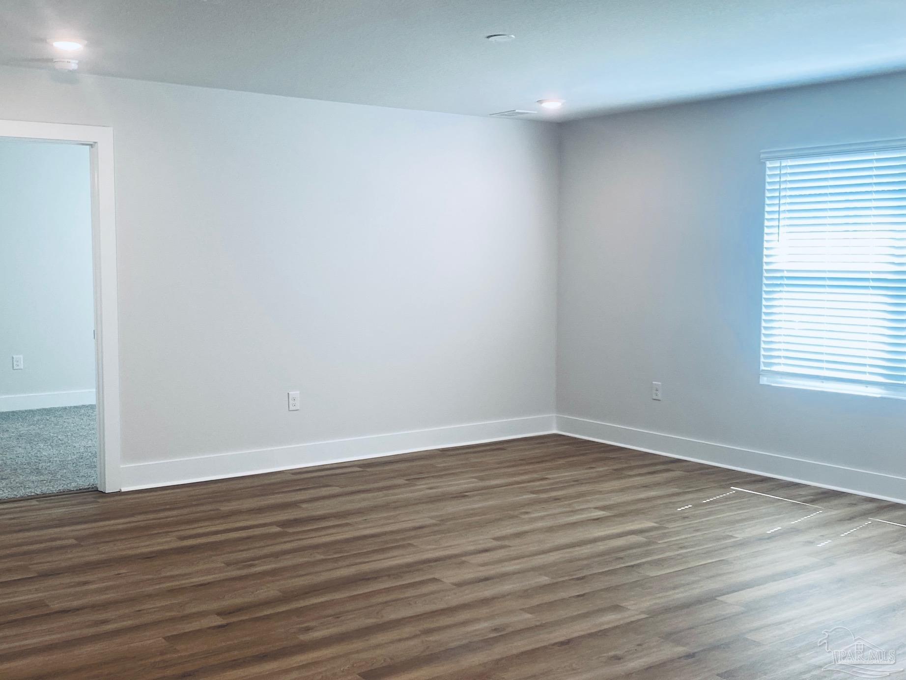 3021 Serviceberry Road Cantonment, FL 32533 - Photo 7 of 21 a view of an empty room with wooden floor and a window