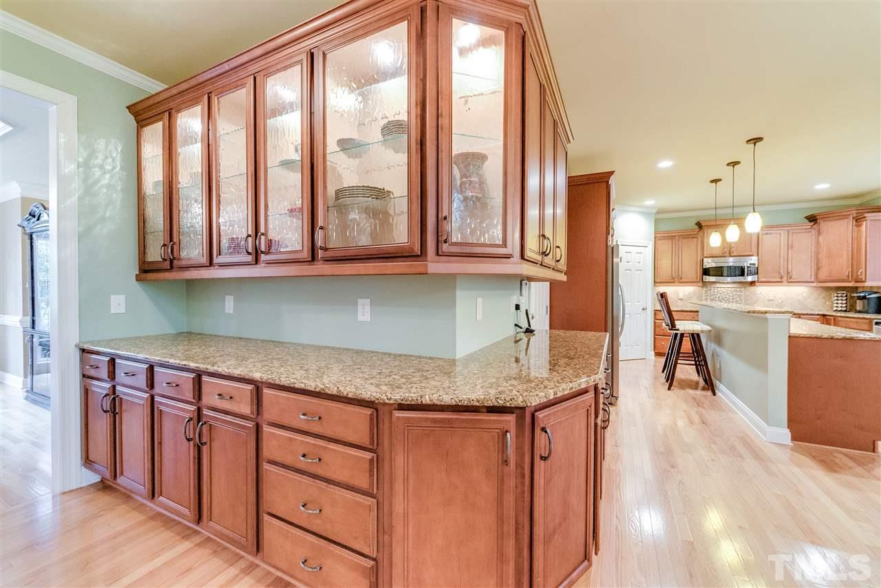 2408 Loring Court Raleigh, NC 27613 - Photo 6 of 25 a kitchen with stainless steel appliances granite countertop a stove a sink and a granite counter tops with wooden floors