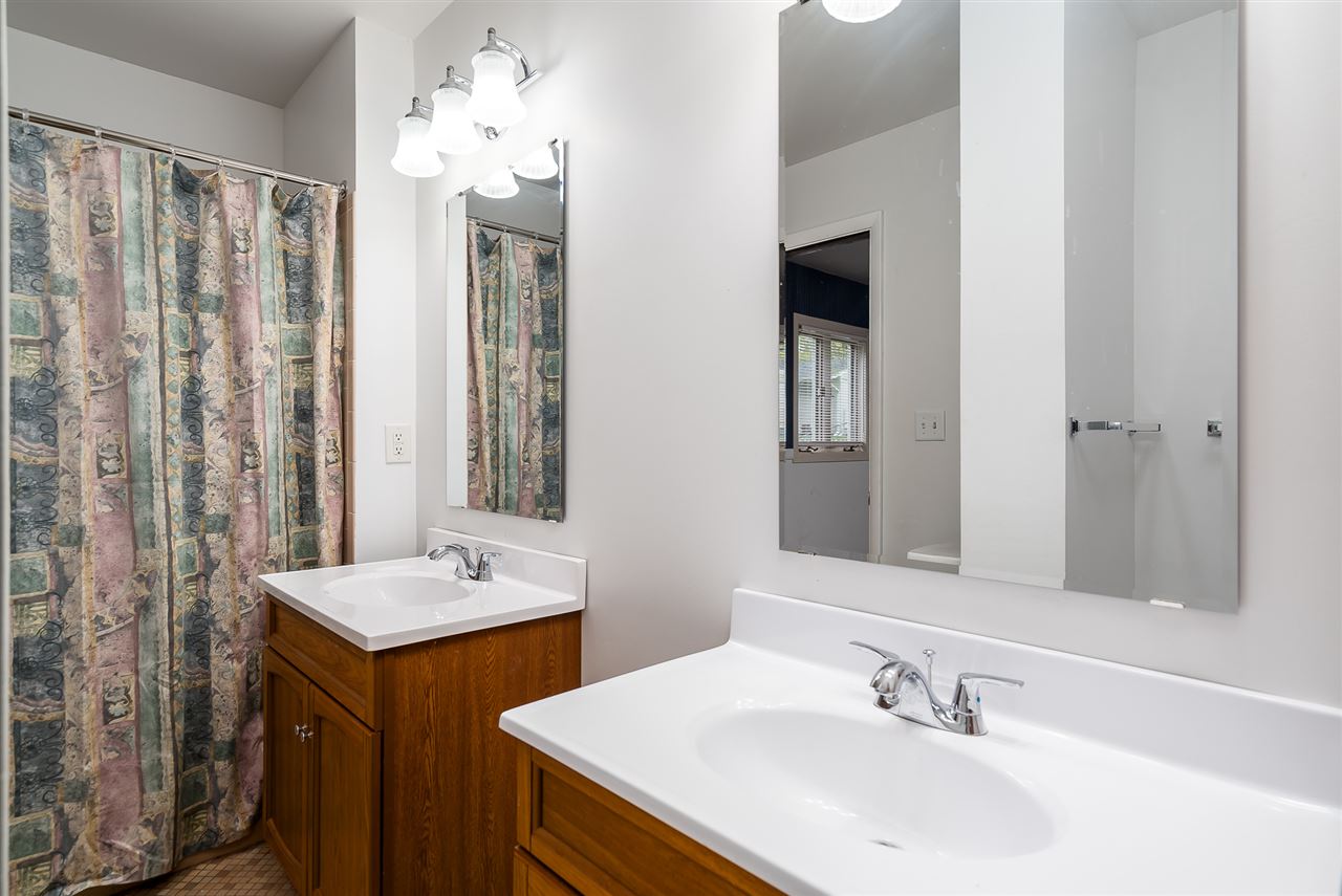 5114 Highcrest Road Rockford, IL 61107 - Photo 22 of 36 a bathroom with double vanity sinks and a mirror