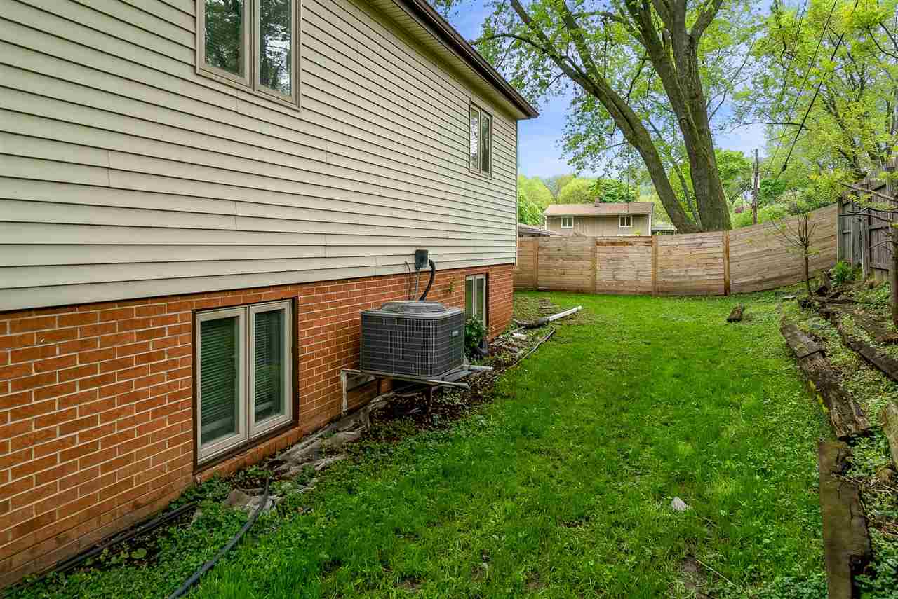 5114 Highcrest Road Rockford, IL 61107 - Photo 34 of 36 a backyard of a house with table and chairs and a large tree