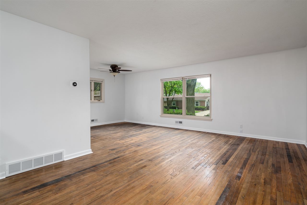 5114 Highcrest Road Rockford, IL 61107 - Photo 5 of 36 an empty room with wooden floor and windows
