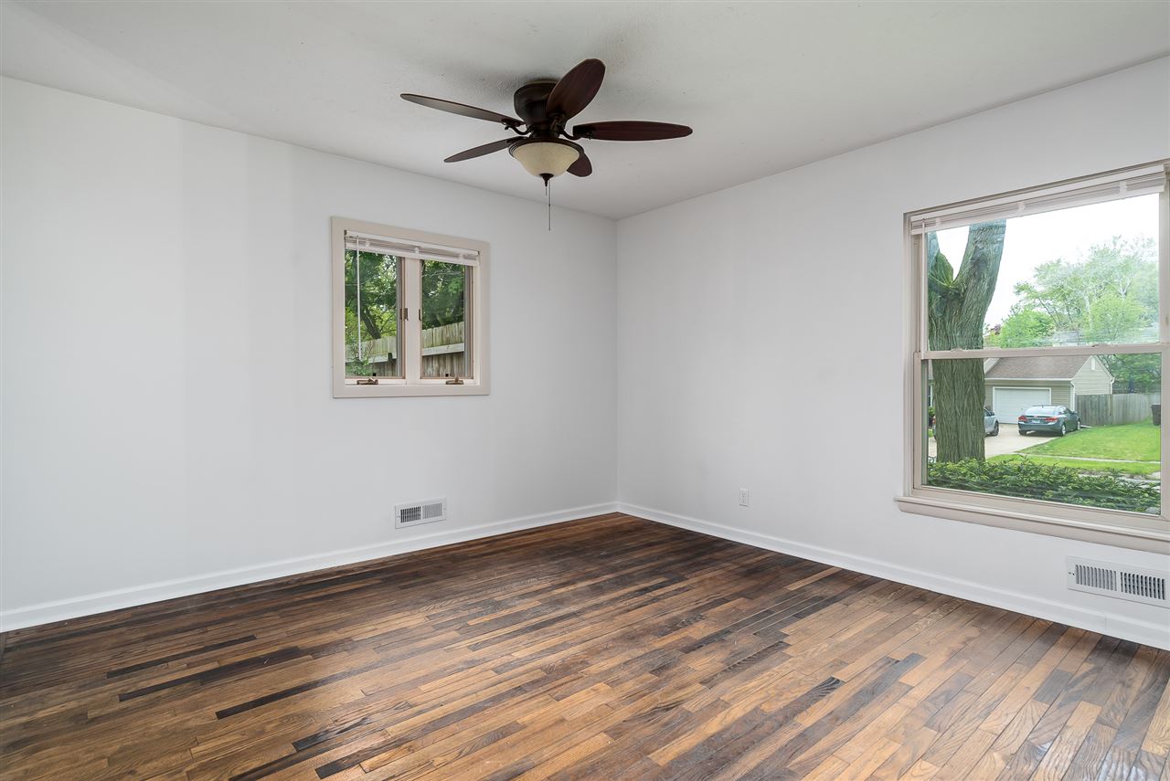 5114 Highcrest Road Rockford, IL 61107 - Photo 10 of 36 a view of empty room with wooden floor and fan