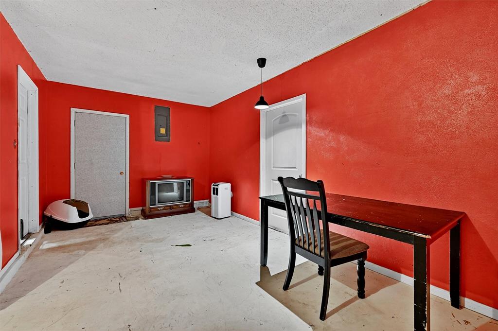 813 Glen Key Street Denison, TX 75020 - Photo 13 of 28 Unfurnished dining area featuring concrete flooring, a textured ceiling, and electric panel