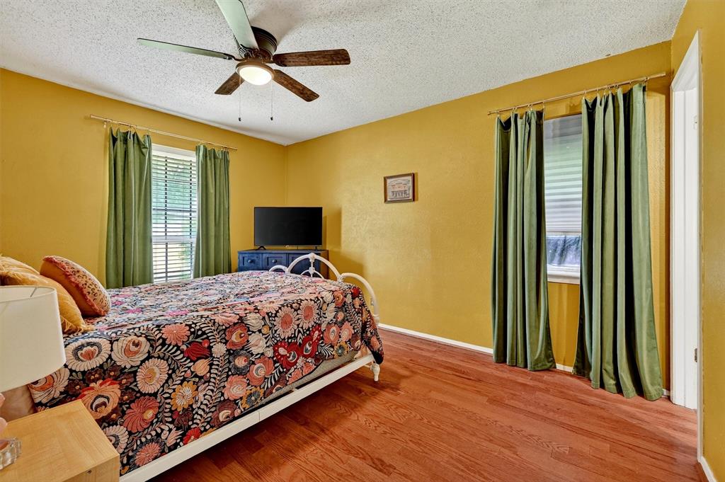 813 Glen Key Street Denison, TX 75020 - Photo 16 of 28 Bedroom with wood finished floors, a textured ceiling, and a ceiling fan