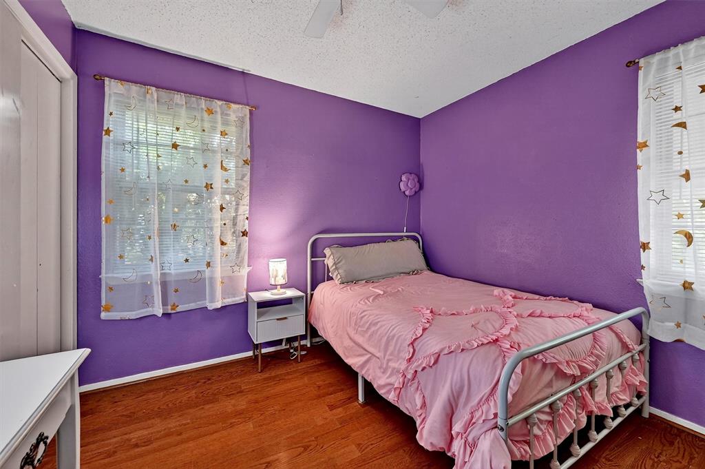 813 Glen Key Street Denison, TX 75020 - Photo 23 of 28 Bedroom with wood finished floors, a textured ceiling, and a ceiling fan
