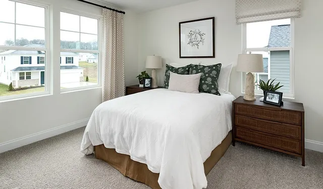 a bed sitting in a bedroom next to a window