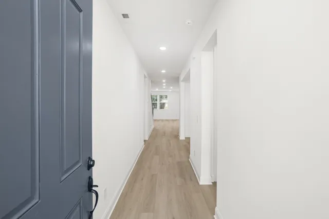 a view of a hallway with wooden floor
