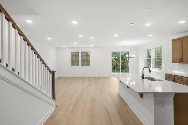 a open kitchen with kitchen island granite countertop a sink and wooden floor