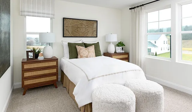 a bed sitting in a bedroom next to a window