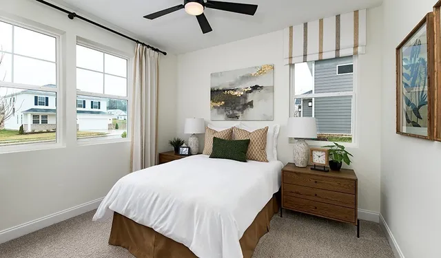 a bedroom with a bed a large window and wall painting