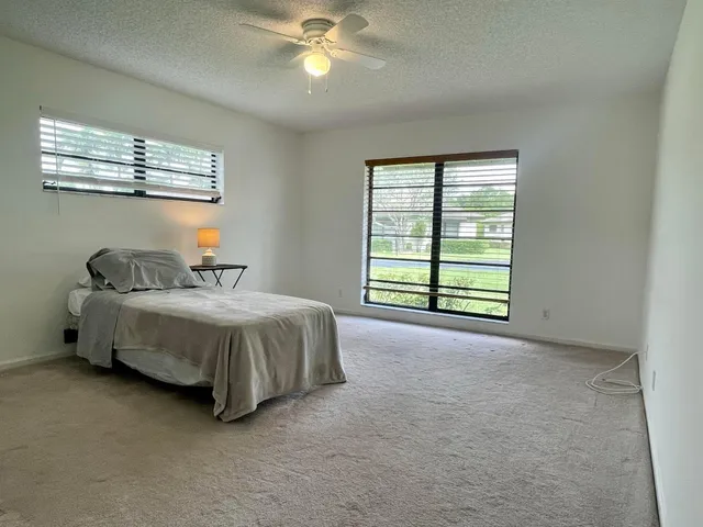 a spacious bedroom with a bed and a chandelier