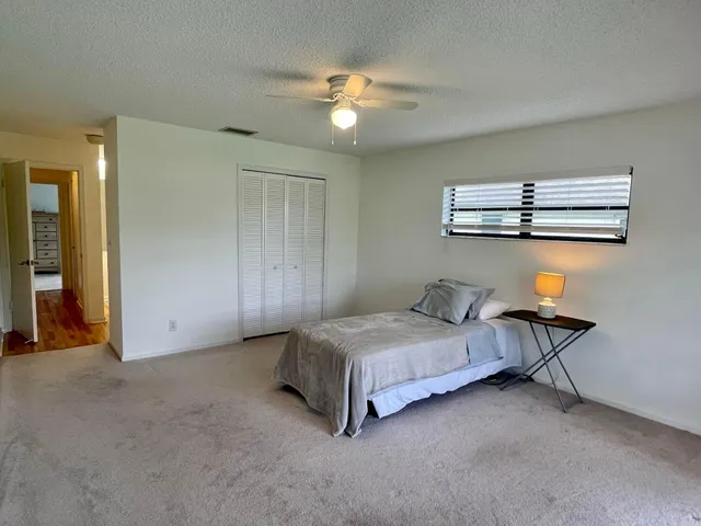 a living room with a bed and ceiling fan