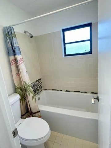 a white toilet sitting next to a bath tub shower