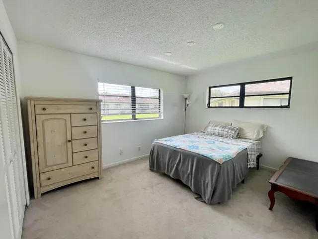 a spacious bedroom with a bed and a window