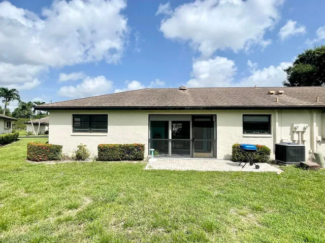 a view of a house with a big yard and large trees