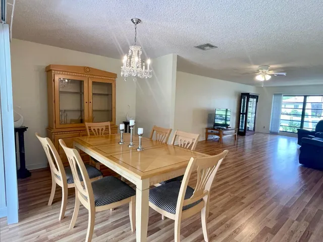 a view of a dining room with furniture wooden floor and chandelier