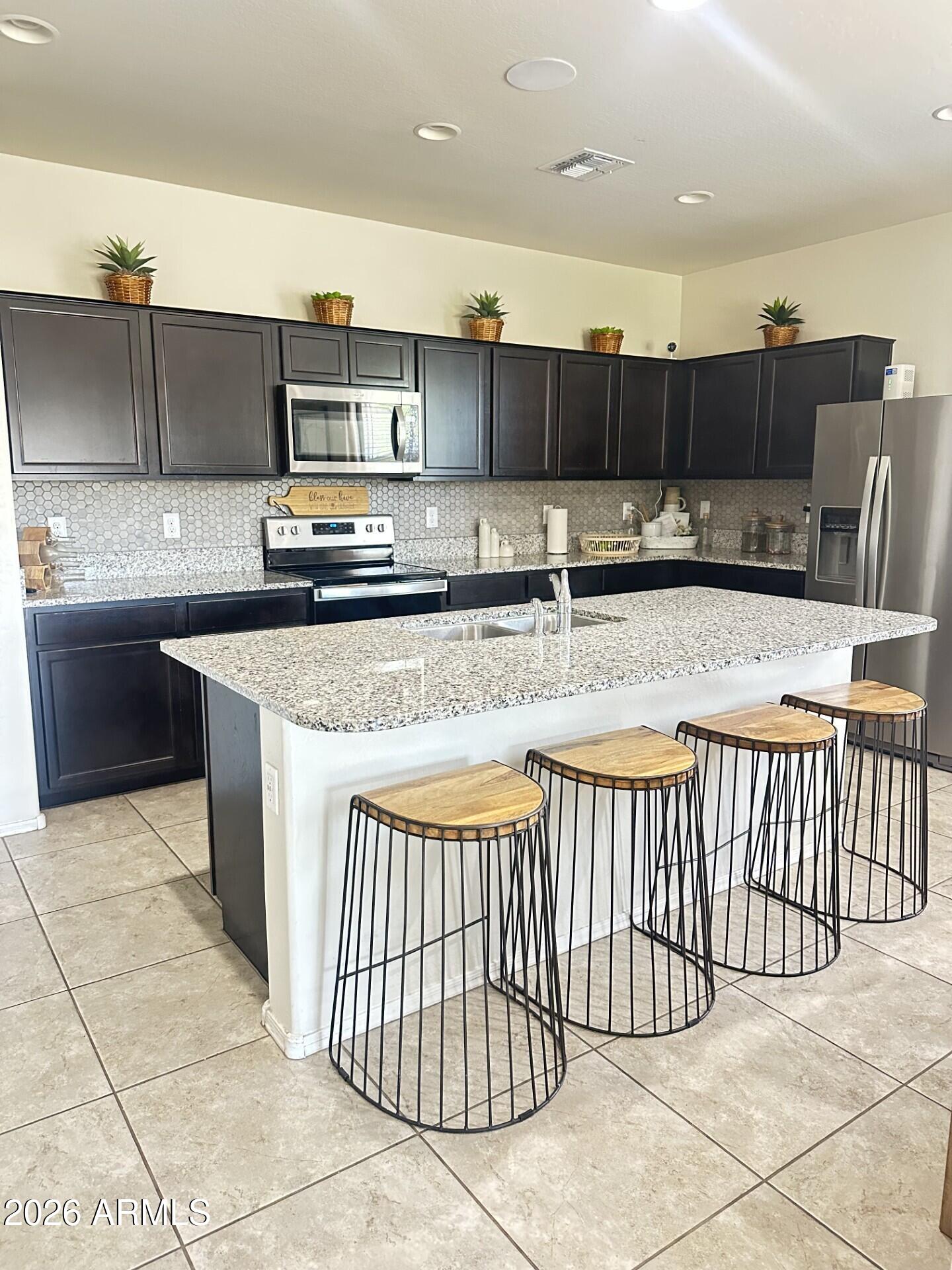 7851 West Riverside Avenue Phoenix, AZ 85043 - Photo 3 of 40 a kitchen with stainless steel appliances granite countertop a sink and cabinets